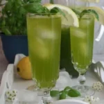Erfrischende Basilikum-Limonade in einem Glas mit frischen Basilikumblättern