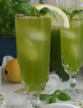 Erfrischende Basilikum-Limonade in einem Glas mit frischen Basilikumblättern