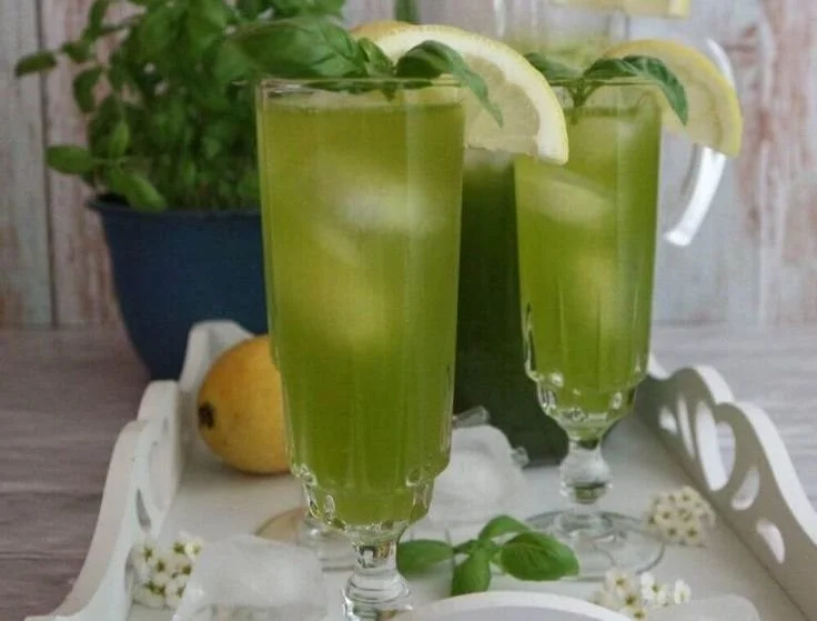 Erfrischende Basilikum-Limonade in einem Glas mit frischen Basilikumblättern