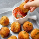 Cremige Pilz- und Erbsen-Arancini auf einem Teller serviert