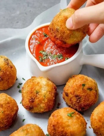 Cremige Pilz- und Erbsen-Arancini auf einem Teller serviert