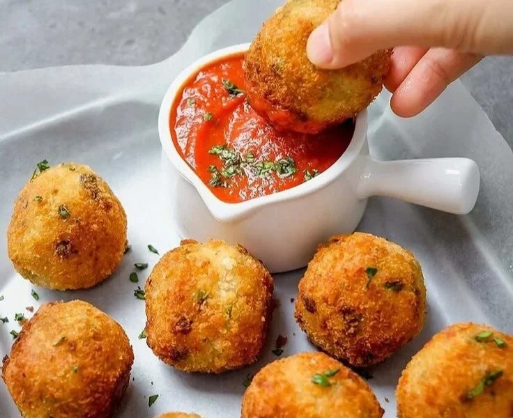 Cremige Pilz- und Erbsen-Arancini auf einem Teller serviert