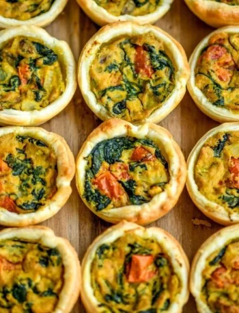 Einfache vegane Mini Quiches auf einem Teller präsentiert.