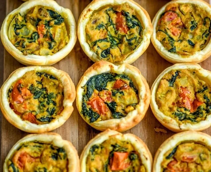 Einfache vegane Mini Quiches auf einem Teller präsentiert.