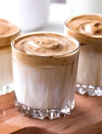 Erfrischender Eiskaffee mit Sahne und Eiswürfeln in einem Glas