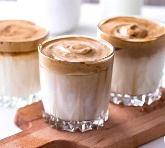 Erfrischender Eiskaffee mit Sahne und Eiswürfeln in einem Glas