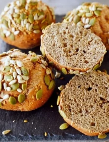 Eiweißbrötchen aus roten Linsen auf einem Holzbrett präsentiert.