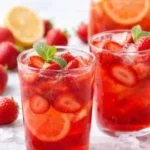 Selbstgemachte Erdbeer Limonade in einem Glas mit frischen Erdbeeren und Minze.