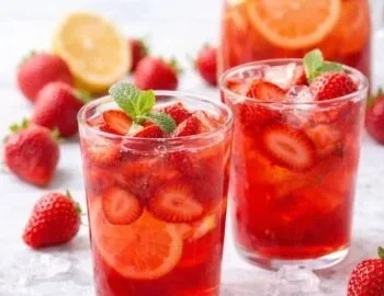 Selbstgemachte Erdbeer Limonade in einem Glas mit frischen Erdbeeren und Minze.
