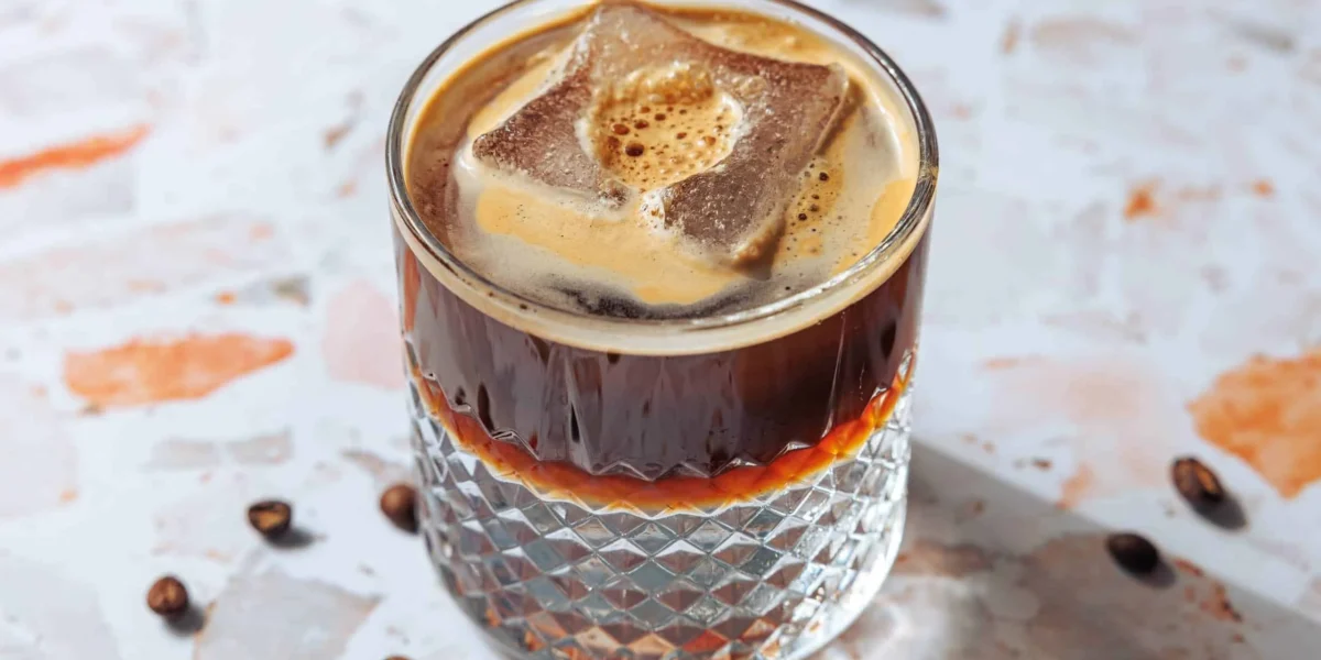 Erfrischendes Espresso Tonic mit Brombeeren im Glas, perfekt für Kaffeefans.