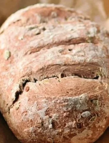 Ein Laib glutenfreies veganes Brot auf einem Holzbrett