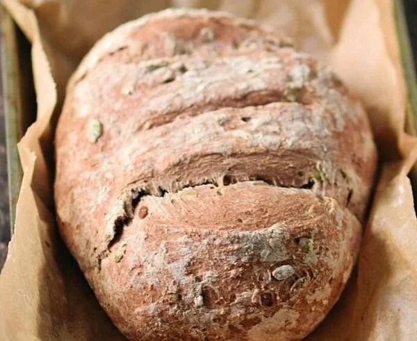 Ein Laib glutenfreies veganes Brot auf einem Holzbrett