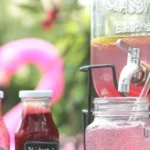 Glas mit Himbeer-Limetten-Limonade auf einem Holztisch, frisch und fruchtig.