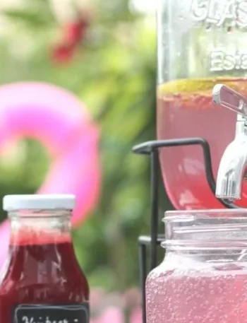 Glas mit Himbeer-Limetten-Limonade auf einem Holztisch, frisch und fruchtig.