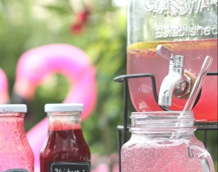 Glas mit Himbeer-Limetten-Limonade auf einem Holztisch, frisch und fruchtig.