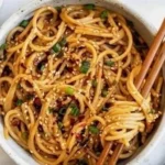 Schüssel mit Knoblauch-Sesamnudeln, garniert mit sesam, frisch und appetitlich.