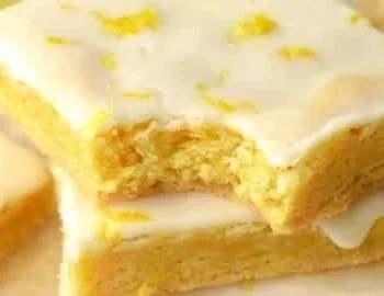 Leckere Zitronen-Brownies auf einem weißen Teller serviert.