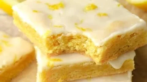 Leckere Zitronen-Brownies auf einem weißen Teller serviert.