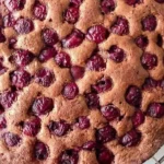 Veganer Schokoladen-Kirschkuchen auf einem Tisch dekoriert mit Kirschen