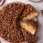 Vegane Pekannuss-Upside-Down-Torte auf einem Teller serviert.