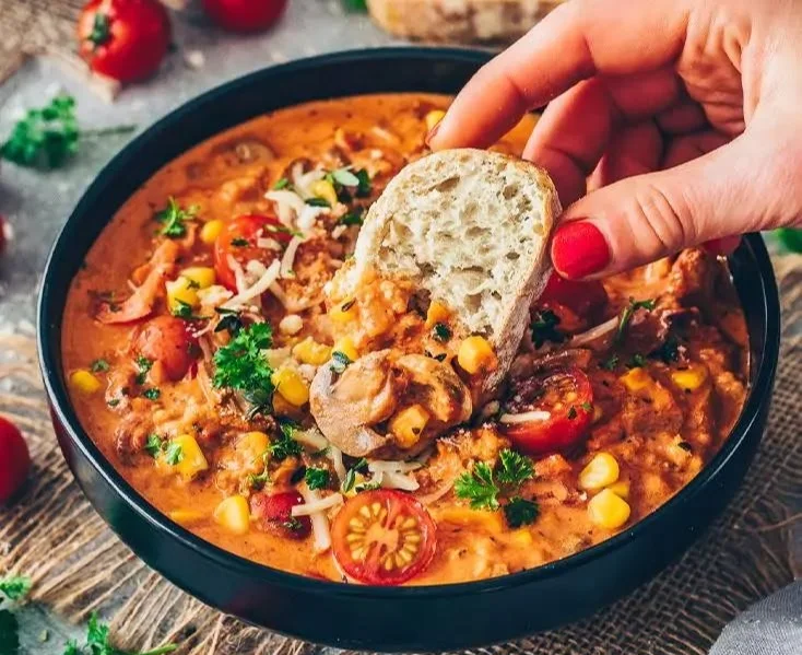 Vegane Pizzasuppe in einer Schüssel mit frischen Zutaten