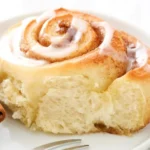 Vegane Zimt Schnecken auf einem Teller, frisch gebacken und verziert.