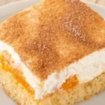 Veganer Fantakuchen mit Mandarinen und veganem Schmand serviert auf einem Teller.