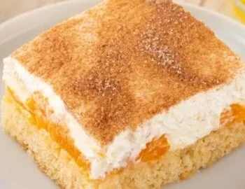 Veganer Fantakuchen mit Mandarinen und veganem Schmand serviert auf einem Teller.