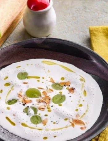 Schüssel mit Ajo Blanco, spanischer Mandelsuppe, garniert mit Mandeln und Olivenöl