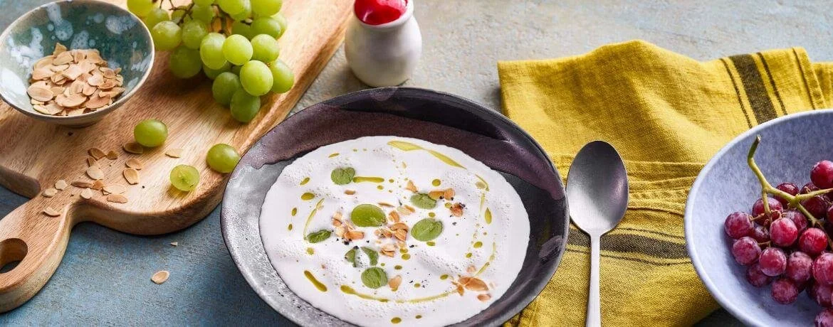 Schüssel mit Ajo Blanco, spanischer Mandelsuppe, garniert mit Mandeln und Olivenöl