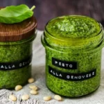 Hausgemachtes Basilikum Pesto in einem Glas mit frischen Basilikumblättern