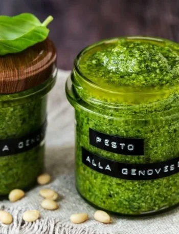 Hausgemachtes Basilikum Pesto in einem Glas mit frischen Basilikumblättern