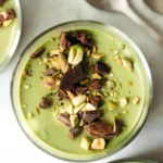 Chocolate Hazelnut Matcha Pudding in einer Schüssel mit Nüssen und Matcha-Pulver dekoriert.