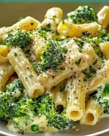 Veganes Brokkoli Alfredo mit weißen Bohnen auf einem Teller serviert.
