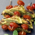 Gegrillte Maultaschen-Spieße auf einem Grill mit Gemüse
