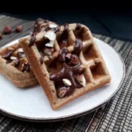 Vegane glutenfreie Haselnuss Waffeln auf einem Teller, angerichtet mit Schokolade