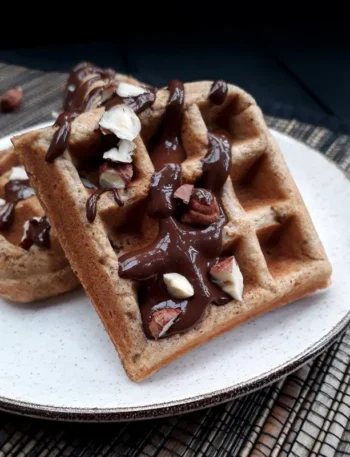 Vegane glutenfreie Haselnuss Waffeln auf einem Teller, angerichtet mit Schokolade
