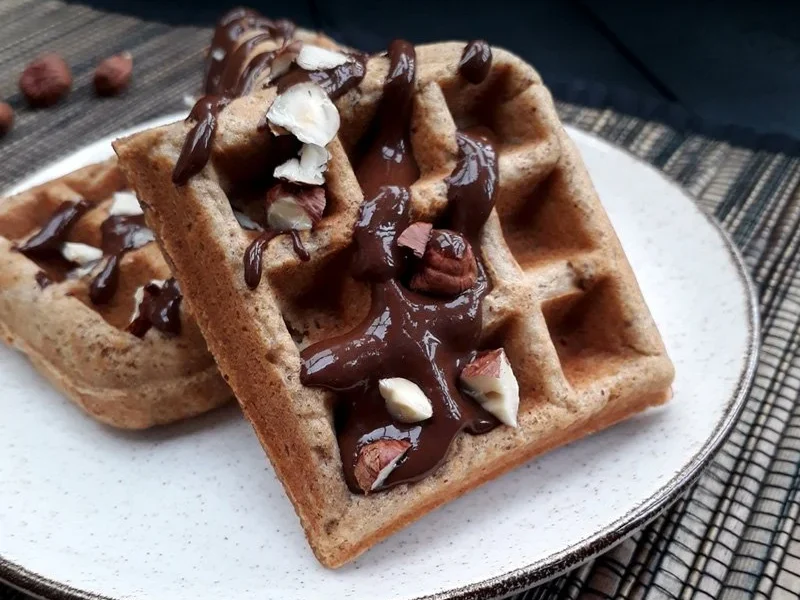 Vegane glutenfreie Haselnuss Waffeln auf einem Teller, angerichtet mit Schokolade