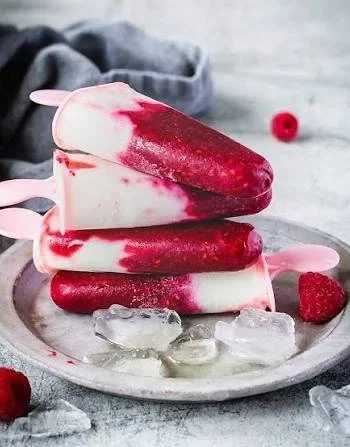 Leckeres Himbeer-Buttermilch-Eis am Stiel auf einem Tisch serviert