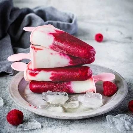 Leckeres Himbeer-Buttermilch-Eis am Stiel auf einem Tisch serviert