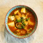 Veganes Kimchi Jjigae, ein würziger koreanischer Eintopf mit Tofu und Gemüse.