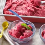 Hausgemachtes Kokos-Himbeer-Eis in einer Schale mit frischen Himbeeren