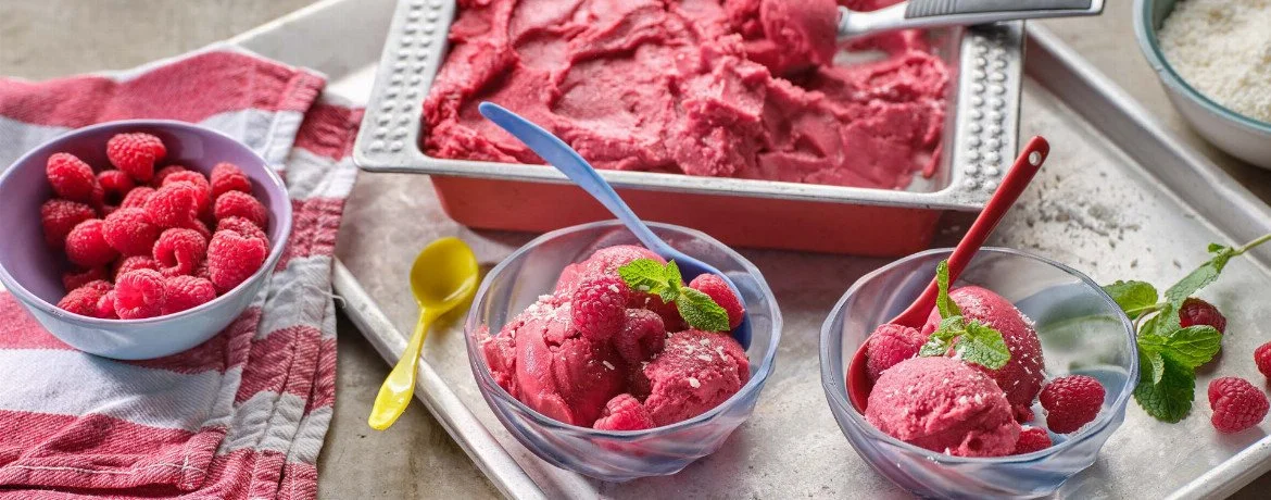 Hausgemachtes Kokos-Himbeer-Eis in einer Schale mit frischen Himbeeren