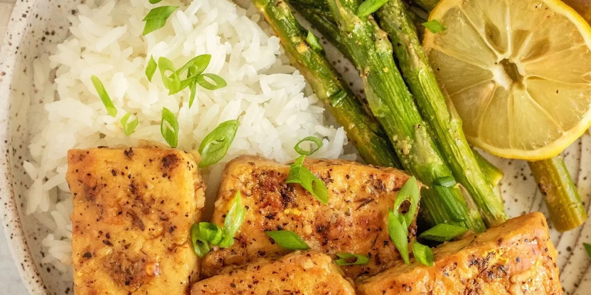 Lemon Pepper Tofu mit frischen Spargelstangen auf einem Teller