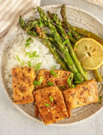 Lemon Pepper Tofu mit frischen Spargelstangen auf einem Teller