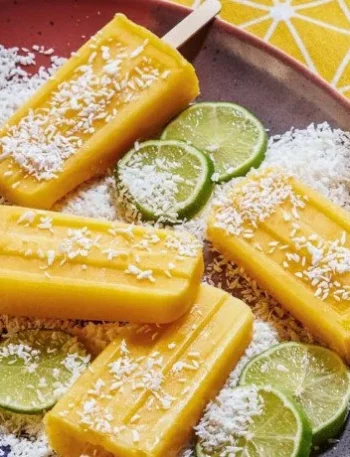 Selbstgemachtes Mango-Limetten-Eis am Stiel in einer bunten Eistruhe