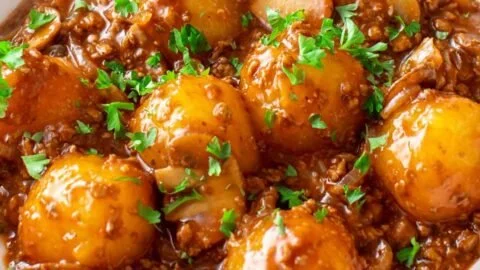 Mini Knödelpfanne mit veganem Hackfleisch, Pilzen und Zwiebeln auf einem Tisch serviert