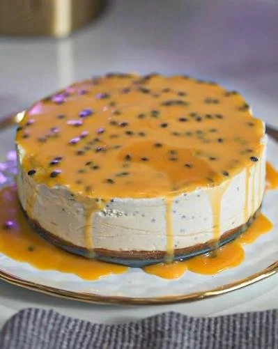 Ein köstlicher Passion Fruit Cashew Cheesecake auf einem weißen Teller