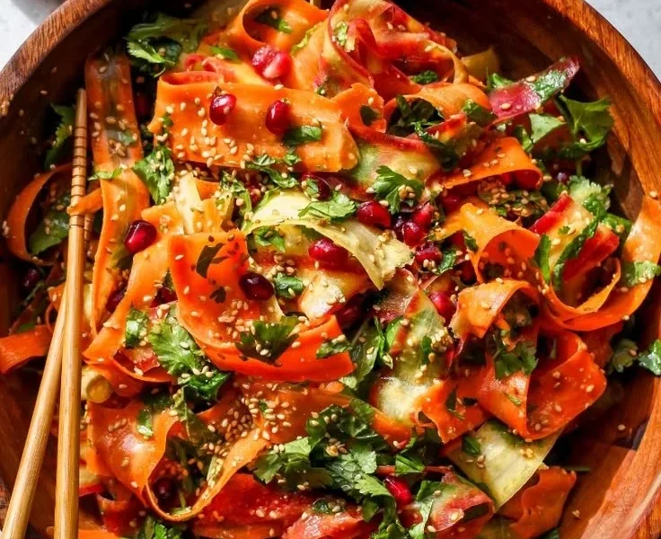 Rohkostmöhrensalat mit Zitrus-Miso-Ingwer-Dressing auf einem Teller