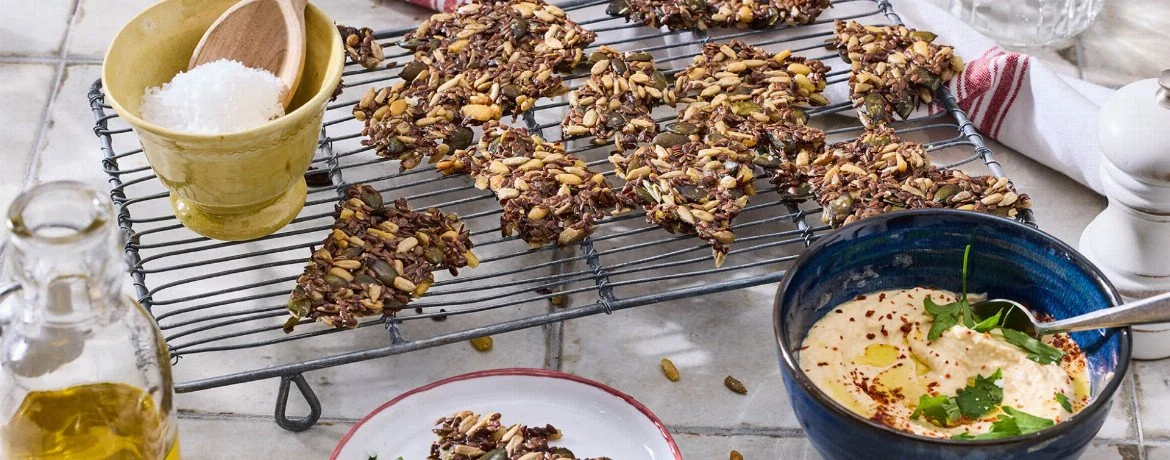 Gesunde Samen-Cracker mit Hummus als Snack